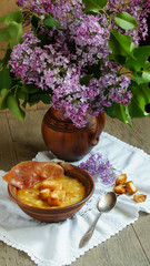 pea soup with bacon and croutons and lilac in ceramic jug 