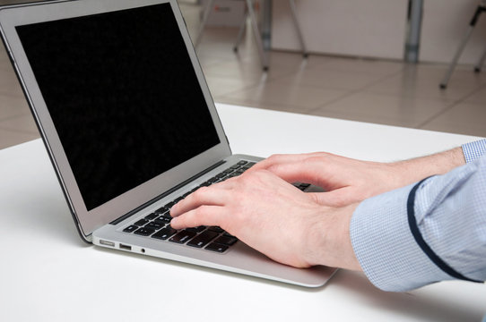 Man's hands typing on laptop. Internet surfing. Programming code
