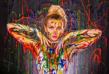 Beautiful young woman covered with paints
