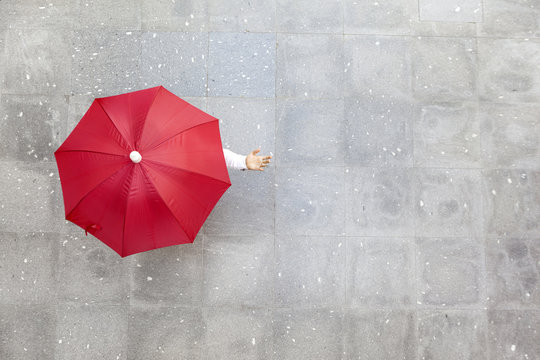 Man holding a red umbrella