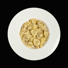 Italian Tortellini Pasta with Alfredo Sauce and Basil. Selective focus.