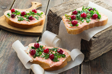 Bruschetta with salmon butter, capelin caviar, cranberry and her