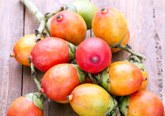 Royal Palm seed fruit on wooden plate