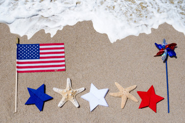 Fototapeta na wymiar American flag with starfishes on the sandy beach