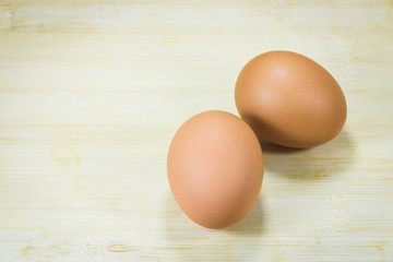 two eggs are on a wood background