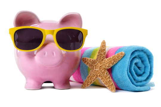 Piggy Bank or piggybank wearing sunglasses sunbathing with beach towel holiday vacation retirement saving money plan photo isolated white background