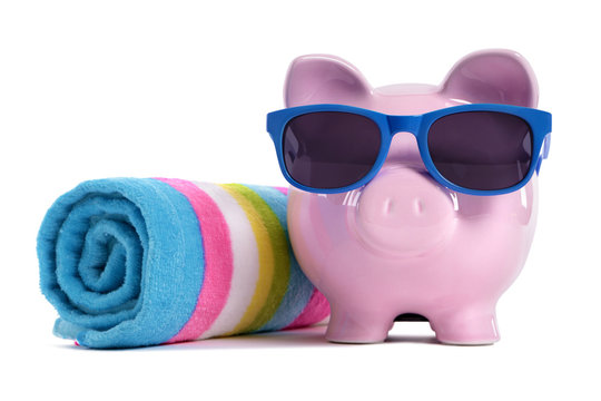 Piggy Bank or piggybank wearing sunglasses sunbathing with beach towel holiday vacation retirement saving money plan photo isolated white background