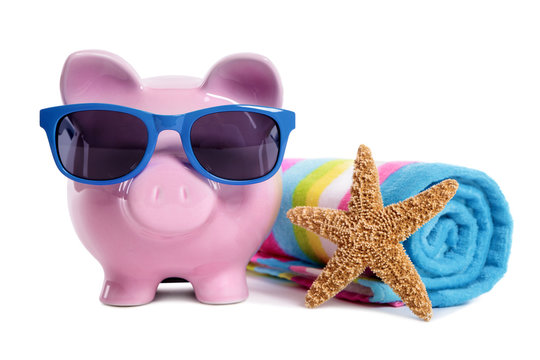 Piggy Bank or piggybank wearing sunglasses sunbathing on beach towel holiday vacation retirement saving money plan photo isolated white background