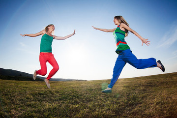 Fototapeta na wymiar Girls jumping in nature, image shot with fish-eye lens