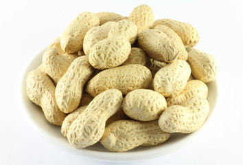 Handful of peanuts in the shell on a white porcelain dish