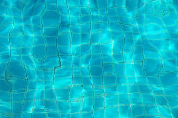 blurred blue water ripple over ceramic floor of swimming pool