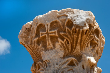 remains of ancient corinthian columns on a background of the blue sky. Caesarea park. Israel