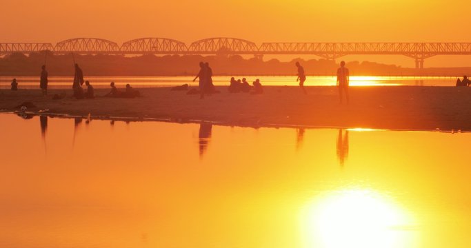 Evening sunset sky reflect in water of Irrawaddy river and young Burmese monks