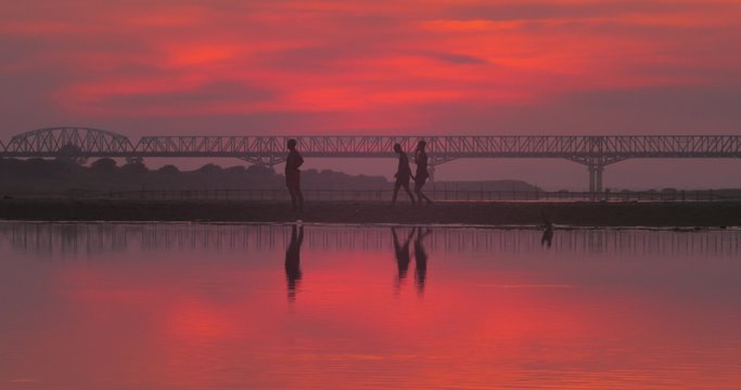 Young monks from local Buddhist temple play soccer on side of Irrawaddy river