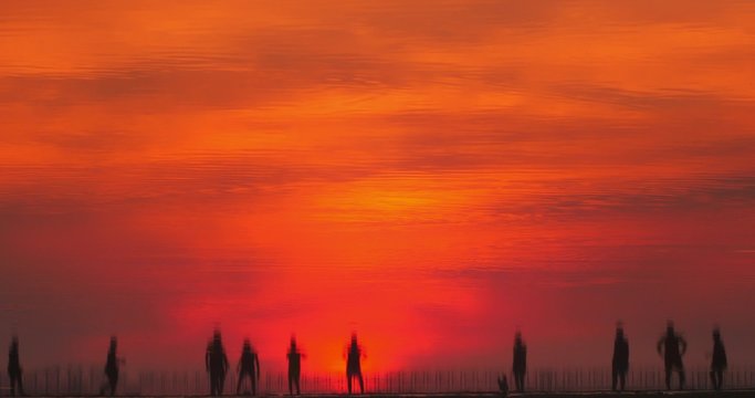 Beautiful reflection in river water of people playing soccer at sunset