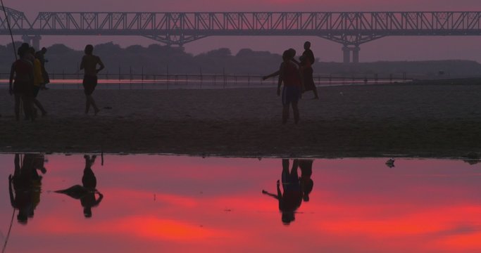 group of young Burmese citizens of local rural village play soccer game on river