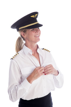 Attractive female airline pilot getting dressed. Tucking shirt into her skirt