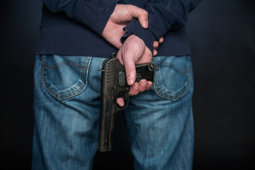 Close up of the rear view of the person who holds a hand gun.