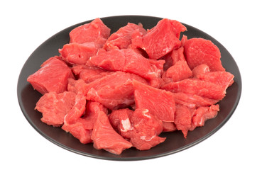 Meat for goulash on the plate isolated.