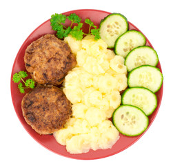 Cutlets with puree and cucumbers on the plate isolated.