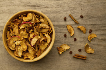 bunch of dried apples in a bowl on old wooden background. Top view