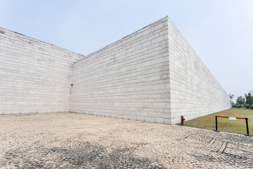 white brick wall and empty sandstone road