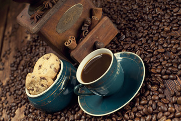 Coffee cup and coffee grains on old planks