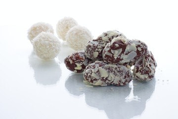 Delicious chocolate pralines in front of coconut balls