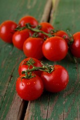 Juicy cherry tomatoes on green table
