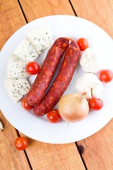 Top view on plate with sausages vegetable and cheese