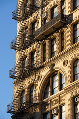 Fototapeta na wymiar Chelsea building with wrought iron balcony and fire escape, Manhattan, New York City
