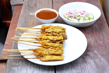 Pork Satay with Peanut Sauce, Wood table background.