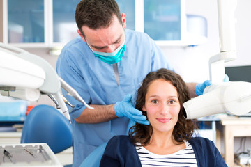 Fototapeta premium Young attractive dentist doing a radiography of woman teeth