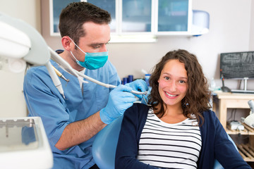Fototapeta premium Young attractive woman being cured by a dentist