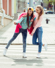 Hipster girlfriends taking a selfie in urban city context -