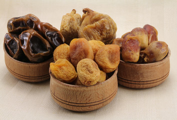 Dried figs, dates, dried apricots in a wooden circular shape