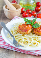 Meatballs in tomato sauce with spaghetti on a white plate