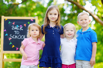 Four adorable little kids are going back to school