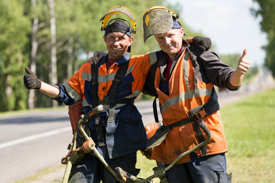 Happy road landscapers with string trimmers gersturing ok sign