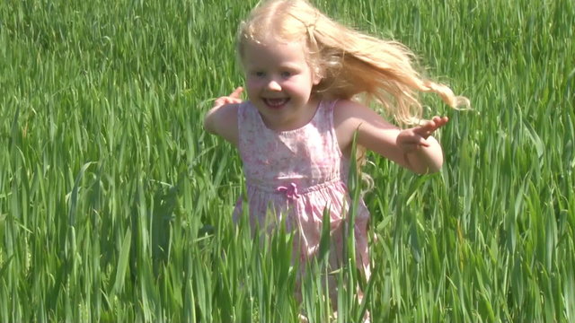 beautiful blonde girl running on the green field