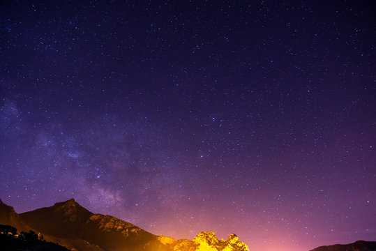 The starry sky above rocky mountains.