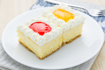 Cake, orange and strawberry flavored berries in white plate.