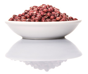 Red adzuki beans in white bowl over white background