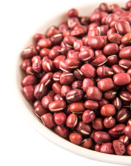 Red adzuki beans in white bowl over white background