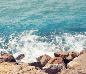 Sea, wave with foam and rocks, abstract travel photo background