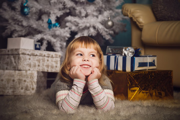 Little girl lying near the christmas tree