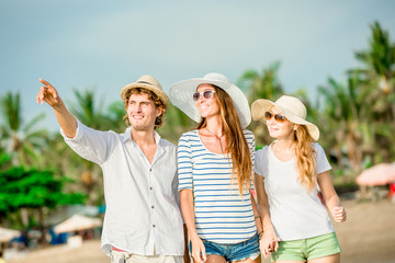 Obraz premium Group of happy young people walking along the beach on beautiful