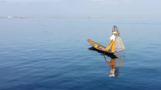 Peaceful nature background of Myanmar. Water reflection of Inle lake fisherman 