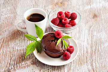 Chocolate muffins with fresh raspberries and a cup of espresso coffee for breakfast. Selective focus