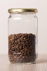 Glass jar with coffee beans on a wooden table